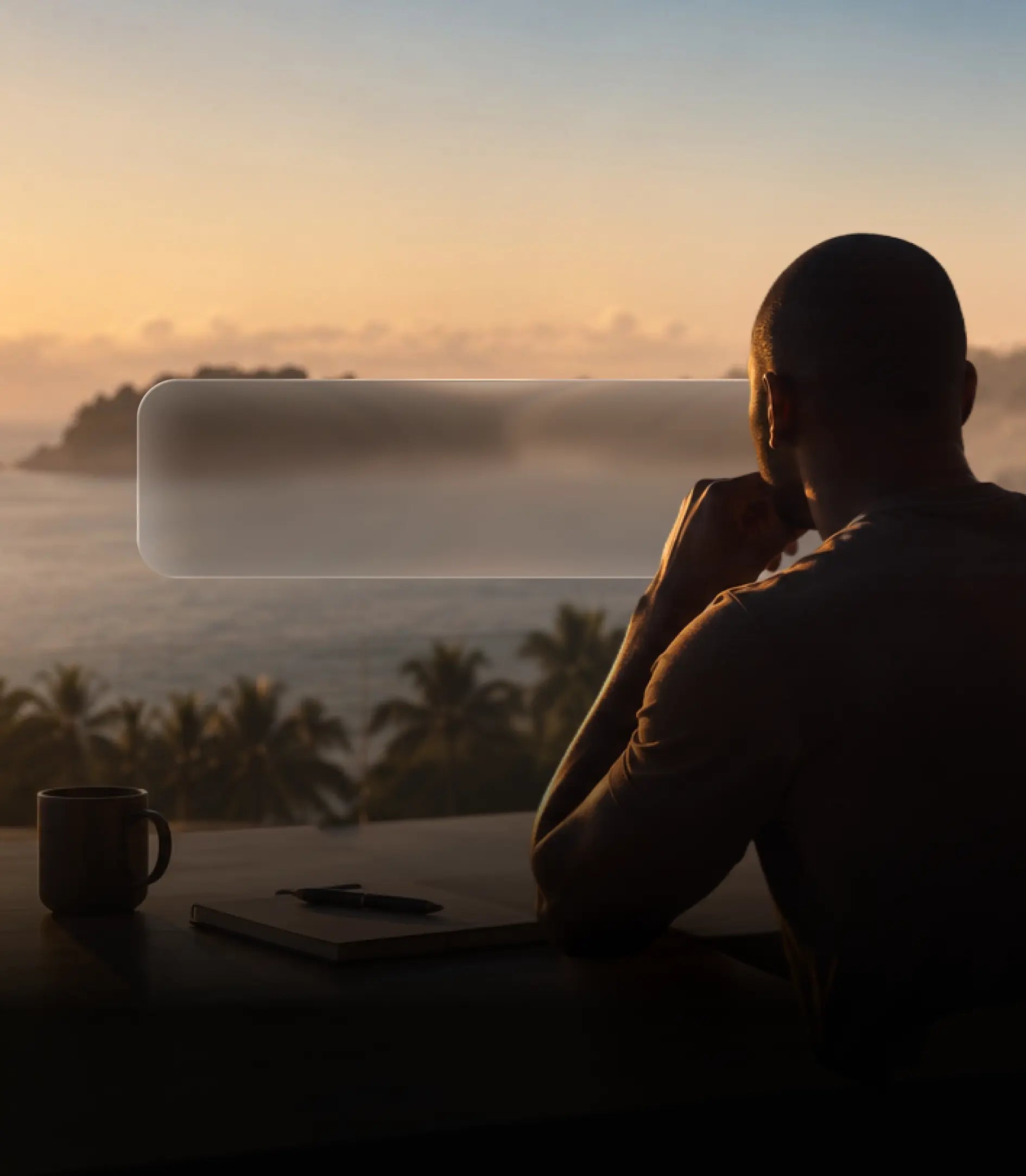 A man reflecting by the ocean at sunrise, with a notebook and pen on the table