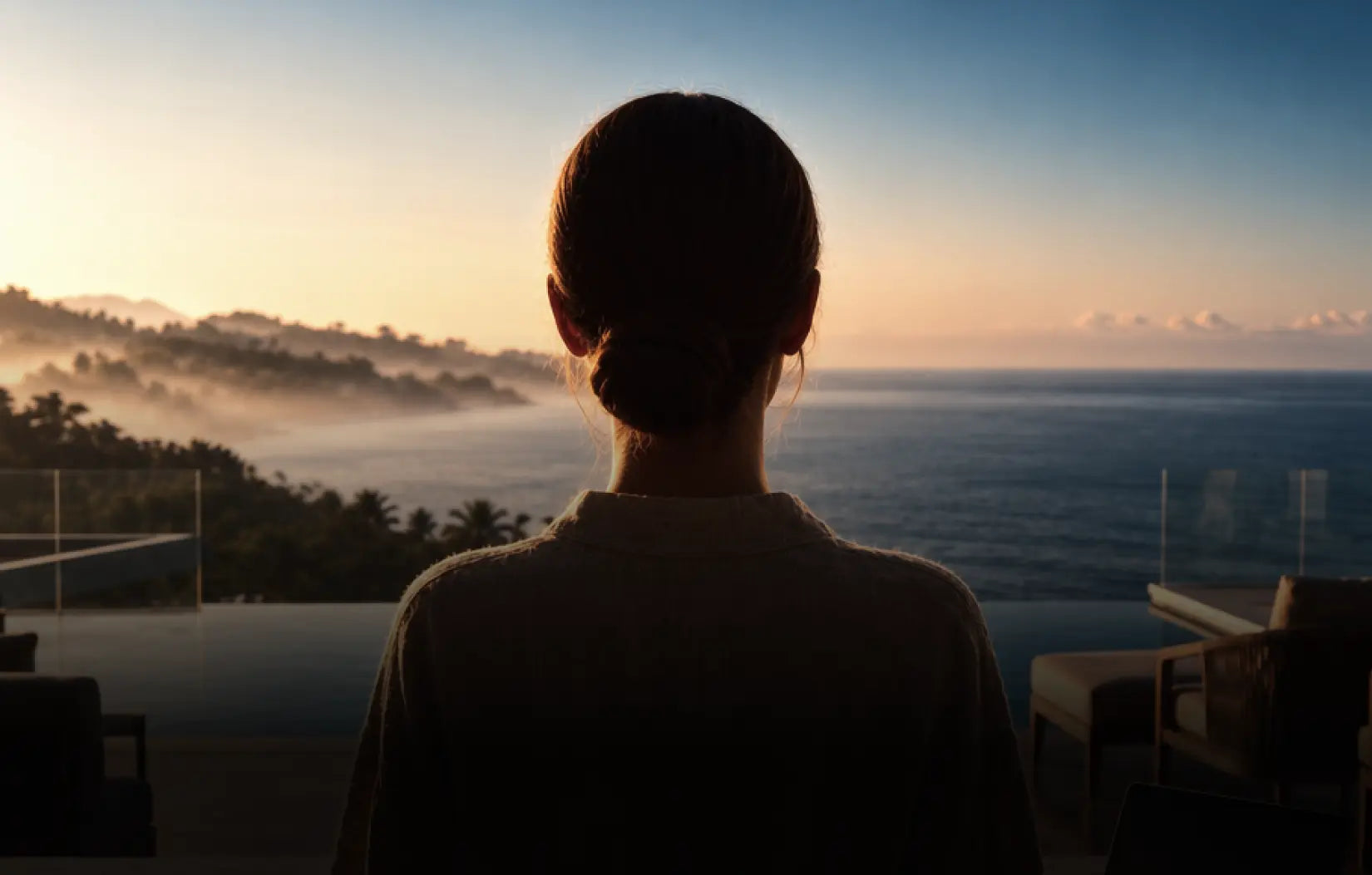 A woman looking out over the ocean at sunrise